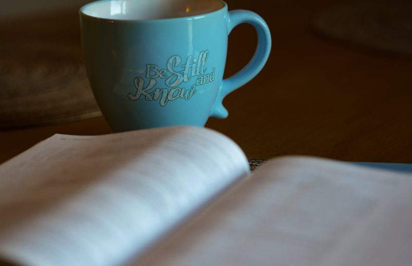 Bible open with coffee mug